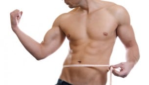 Muscular man measuring waist